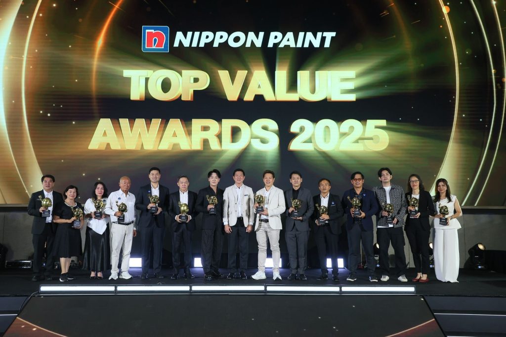 A line of award winners holding gold trophies on stage at the Nippon Paint Top Value Awards 2025.