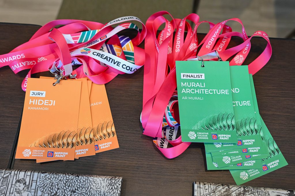 Close-up of colourful Creative Colour Awards lanyards and participant name tags resting on a table.