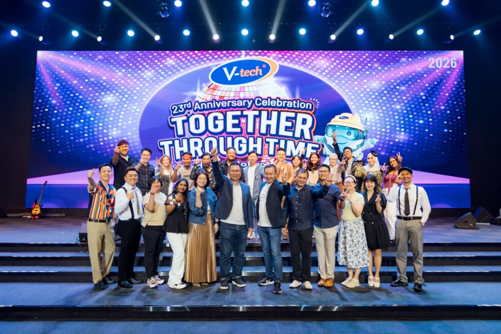 V-tech Malaysia employees and management posing on stage at their annual dinner.